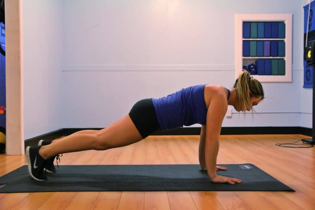 a woman doing push ups on a mat