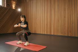 a woman doing squats on a mat